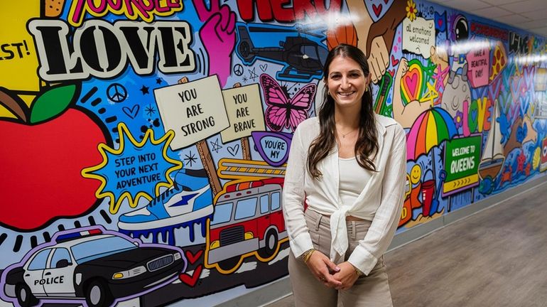 Artist Corey Bloomberg in front of a mural she donated...