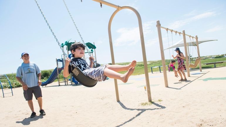 Ari Chasin, of Brooklyn, plays on the playground with his...