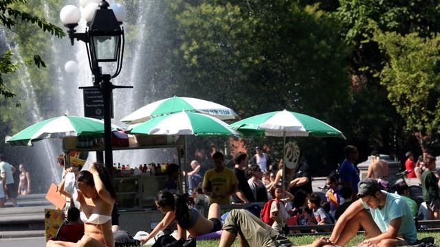 People take in the sun at Washington Square Park