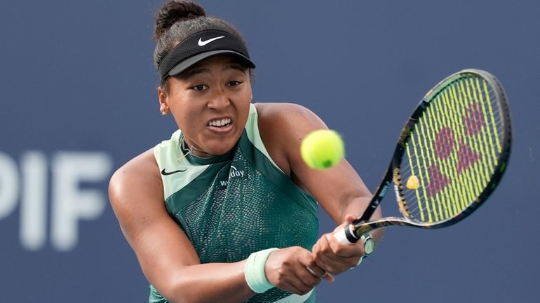 Naomi Osaka, of Japan, hits a return to Caroline Garcia,...