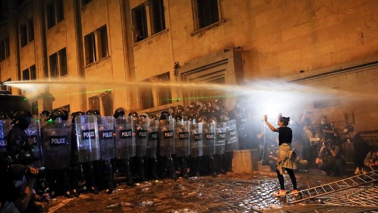 FILE A demonstrator gestures trying to stop riot police during...