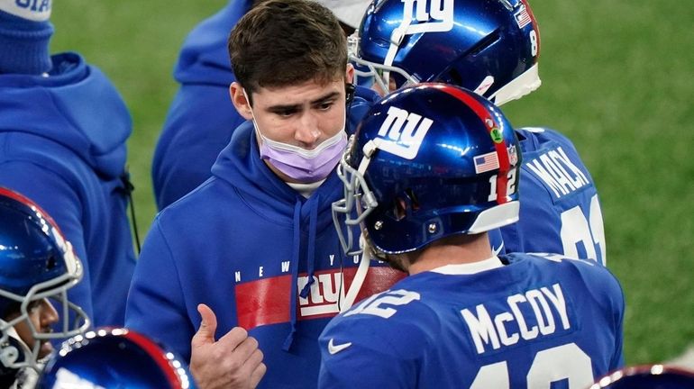 Giants quarterback Daniel Jones, center, talks to quarterback Colt McCoy...