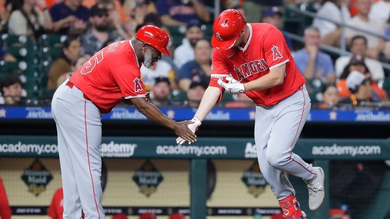 Los Angeles Angels third base coach Eric Young Sr., left,...