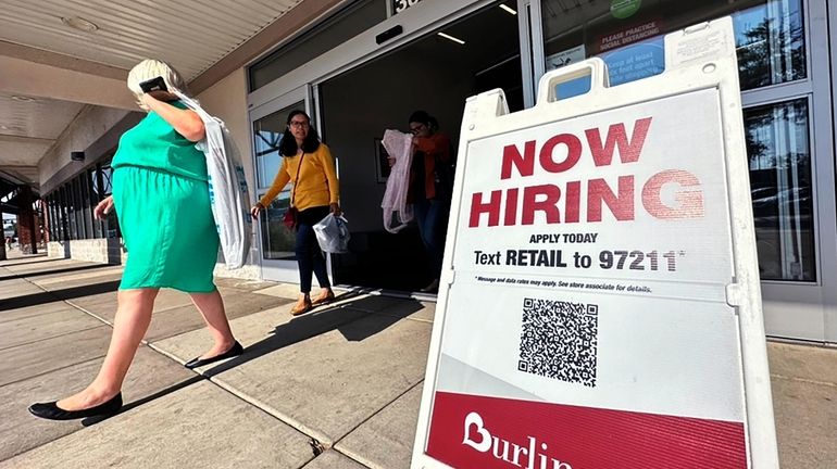 A hiring sign is displayed at a retail store in...