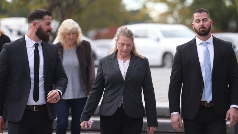 Ann Marie Drago, center, of Patchogue, arrives at Suffolk County...