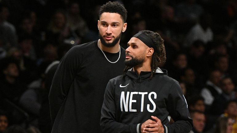 Brooklyn Nets guards Ben Simmons, background, and Patty Mills against...