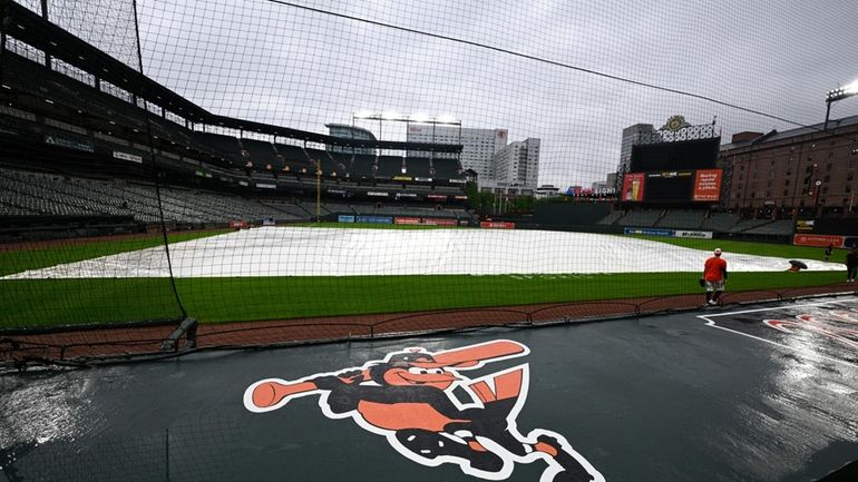 The tarp covers the field as the baseball game between...