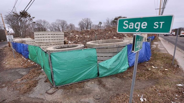 Mounds of debris are piled high on a fenced-in property...