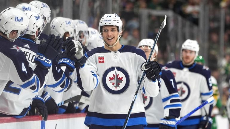 Winnipeg Jets center Morgan Barron, center, celebrates with teammates after...