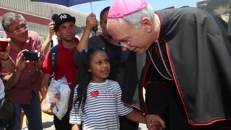 El Paso Catholic Bishop Mark Seitz talks with Celsia Palma,...