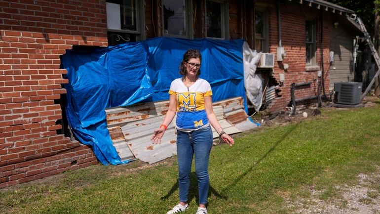 Terra Hillman shows the exterior damage that still exists to...