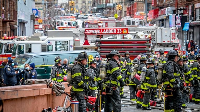 Firefighters and paramedics at the scene Sunday in the Bronx. About...