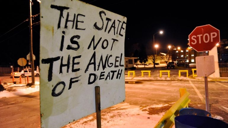 A sign placed by death penalty opponents sits in front...