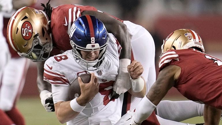 Giants quarterback Daniel Jones is tackled by 49ers defensive tackle Javon Kinlaw,...