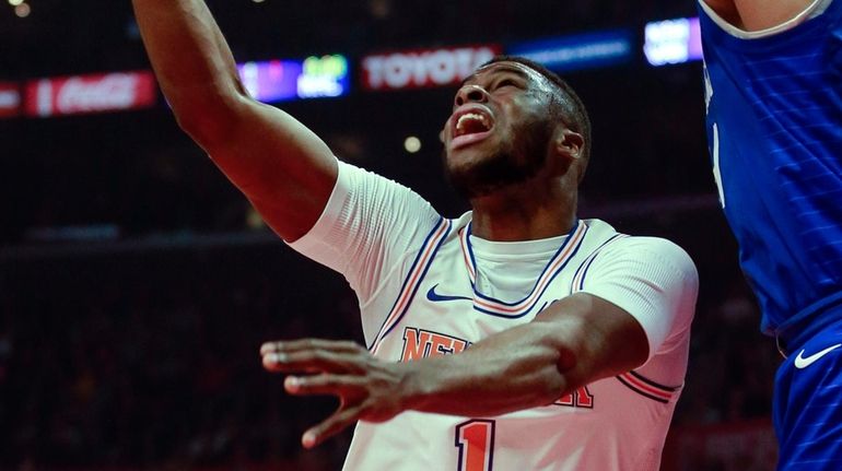 Knicks guard Emmanuel Mudiay, left, goes to the basket while...