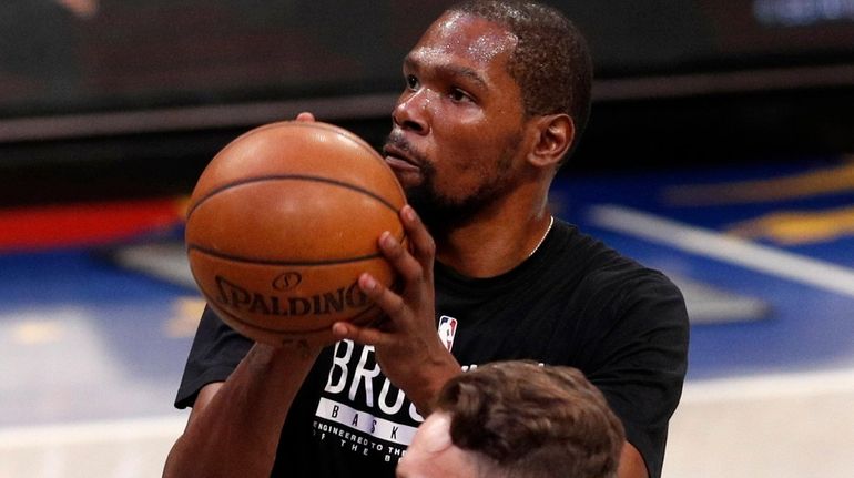 Kevin Durant of the Nets warms up on the court...