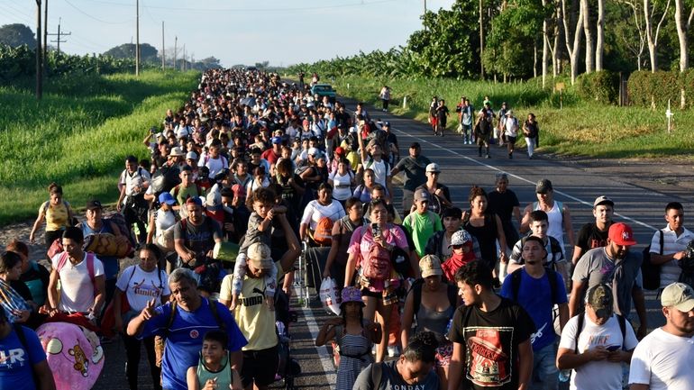 Migrants walk along the highway through Suchiate, Chiapas state in...