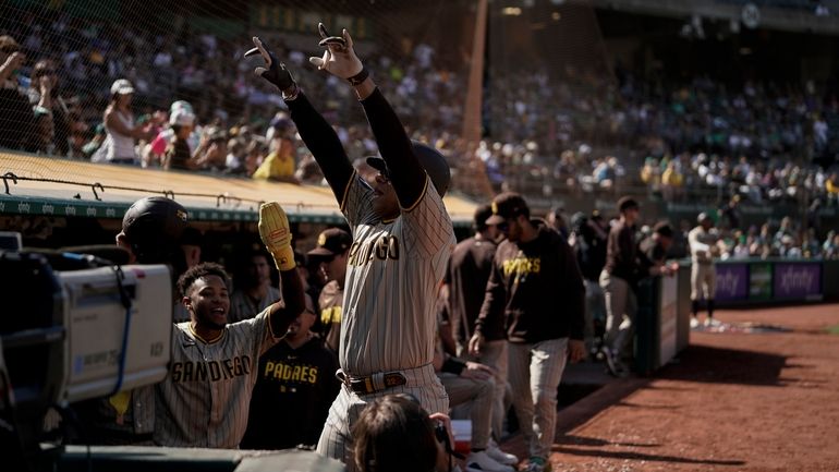 San Diego Padres' Juan Soto, center, gestures to the crowd...