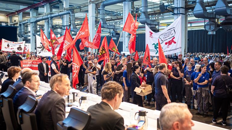 Employees protest before the start of a works meeting in...