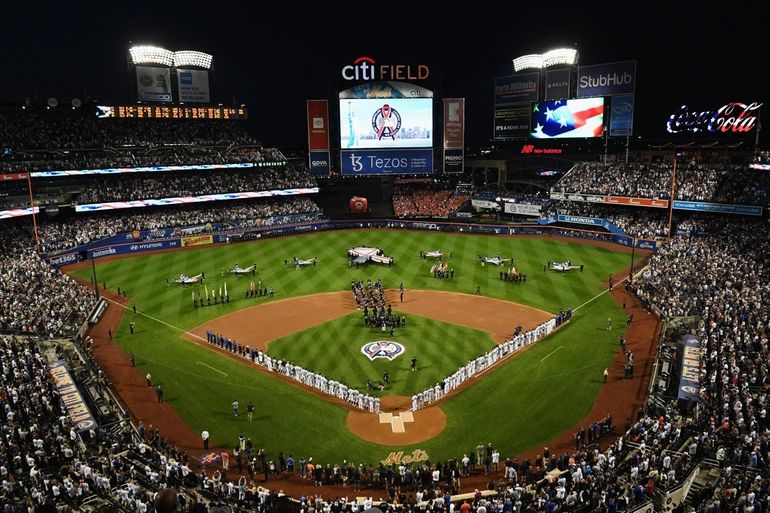 The New York Yankees and the New York Mets shake hands before lining up  together along the baselines for the 20th anniversary of the 9/11 terrorist  attacks before a baseball game on