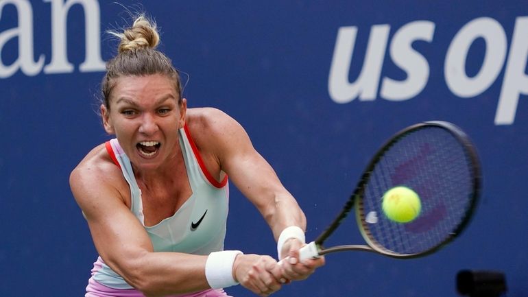 Simona Halep, of Romania, returns a shot to Daria Snigur,...