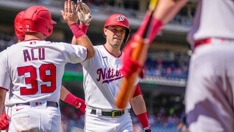 Washington Nationals' Lane Thomas celebrates with teammate Jake Alu (39)...