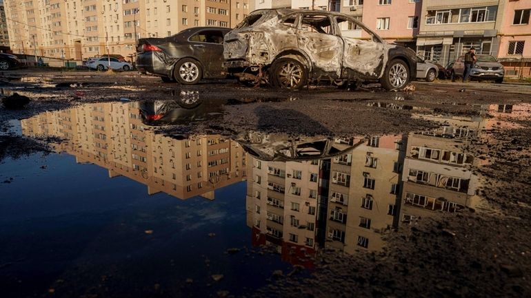 Destroyed cars are seen on a parking after Russian airstrike...