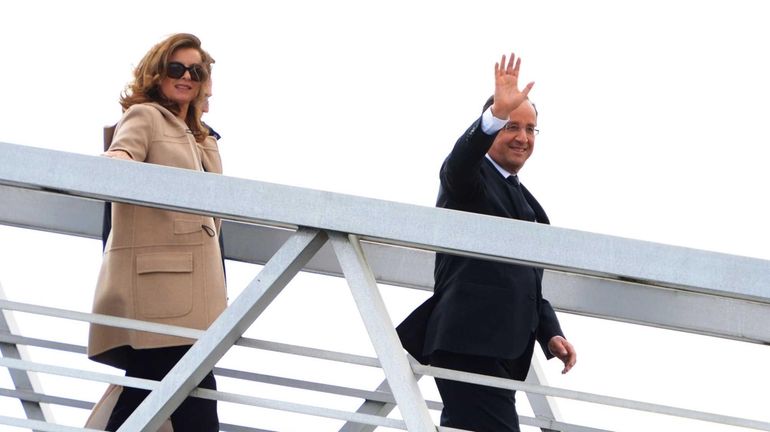 French President Francois Hollande (R), flanked by his companion Valerie...