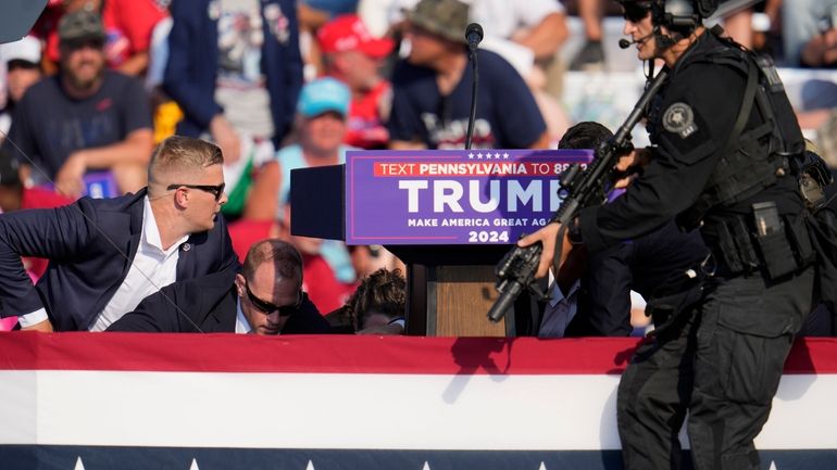 Republican presidential candidate former President Donald Trump is surrounded by...