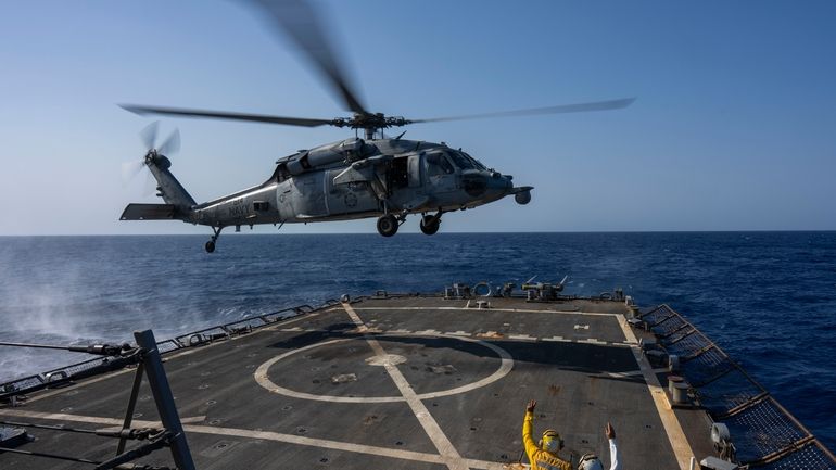 An HSC-7 helicopter lands on the Arleigh Burke-class guided missile...