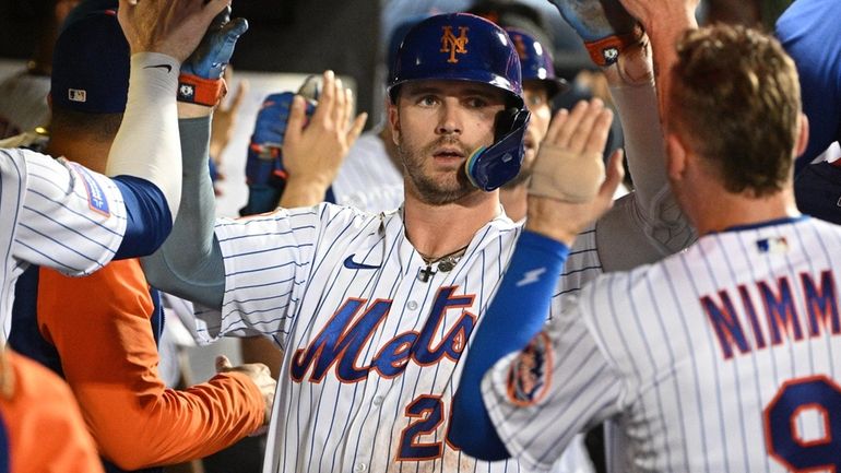 The Mets' Pete Alonso is greeted in the dugout after...