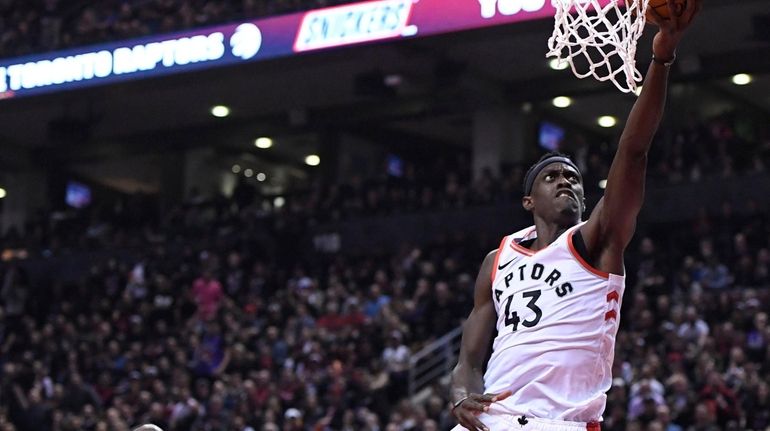 Raptors forward Pascal Siakam lays the ball in as Warriors forward...