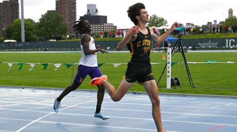 Robert Doherty from St. Anthony crosses the finish line to...