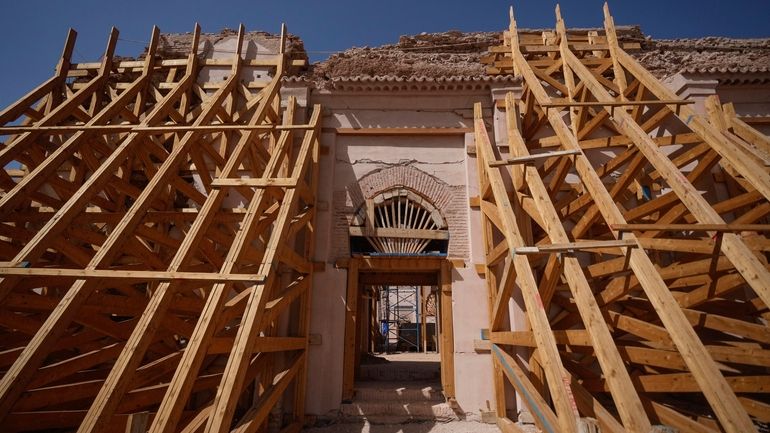 A wooden structure supports the Great Mosque of Tinmel which...