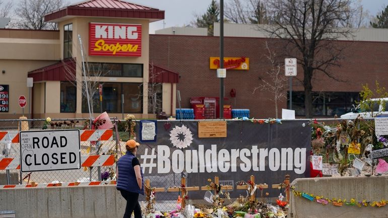 Tributes cover the temporary fence around the King Soopers grocery...