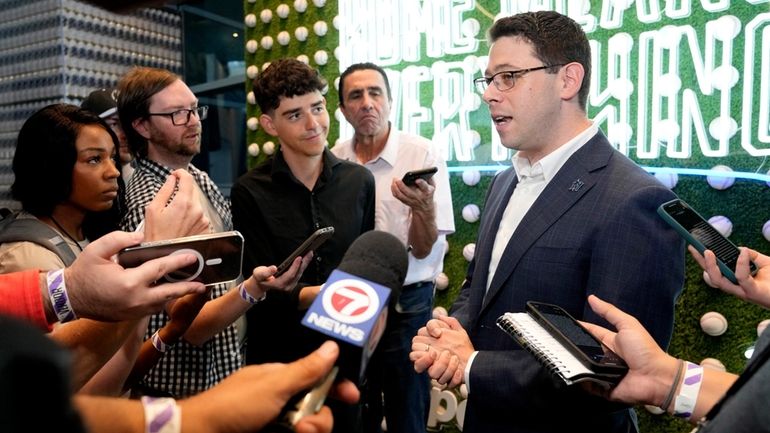 Peter Bendix, Miami Marlins president of baseball operations, right, speaks...