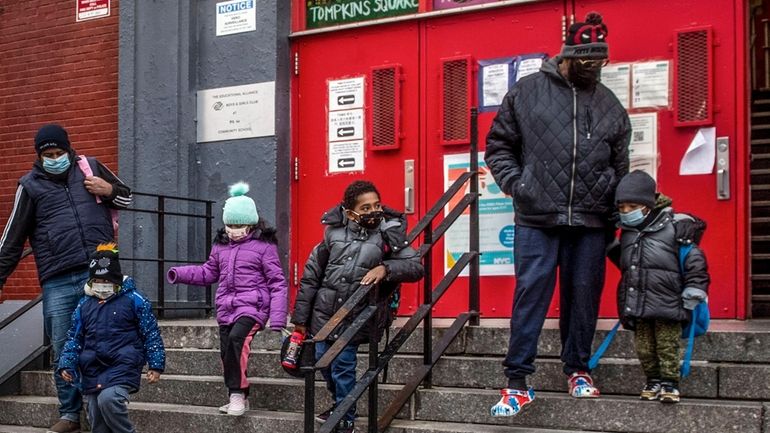 Children and their guardians wear masks as they leave P.S. 64...