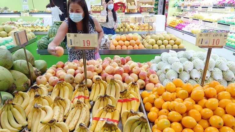 People buy fruit at a stall in Taipei, Taiwan, on...