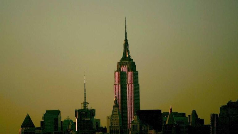 The Empire State Building in the early evening light as...