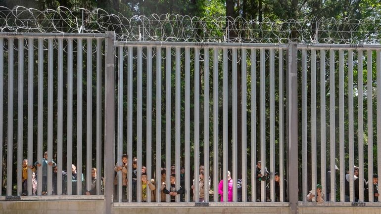 Members of a group of some 30 migrants seeking asylum...