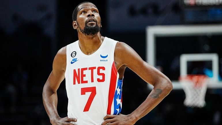 Nets forward Kevin Durant looks at the clock during the...