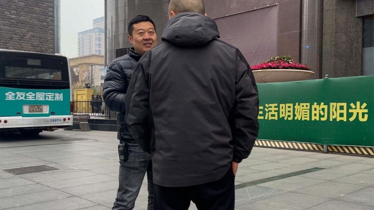 Plainclothes policemen have a chat as they stand watch outside...