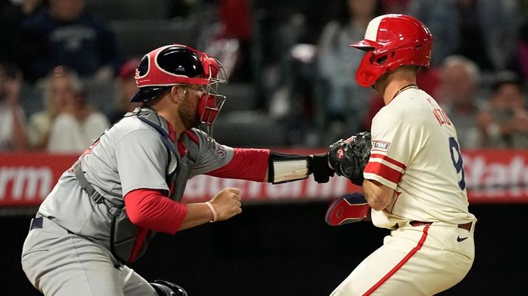 Los Angeles Angels' Zach Neto, right, is tagged out by...