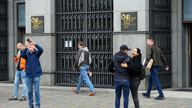 People stand outside the Czech central bank in Prague, Czech...