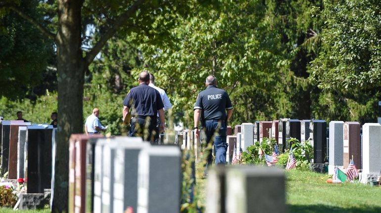 Investigators at St. Charles Cemetery on Wellwood Avenue in East...