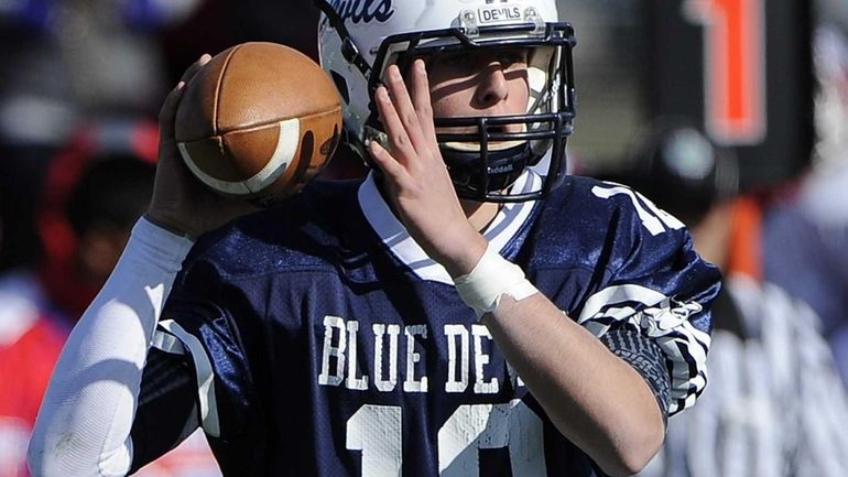 Huntington quarterback Ben Kocis looks to pass against Bellport during...