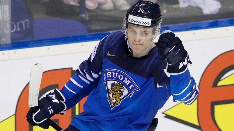 Finland's Kaapo Kakko, up, celebrates with Harri Pesonen, down, after...