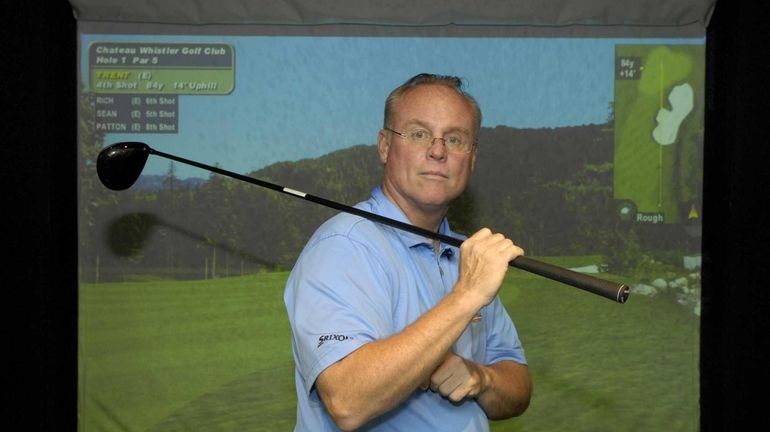 Teaching professional Allan Renz poses near the full swing simulator...