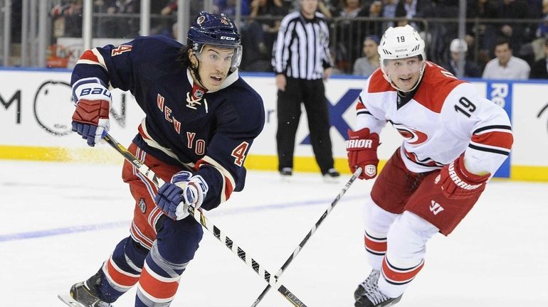 Michael Del Zotto chases the puck ahead of the Carolina...