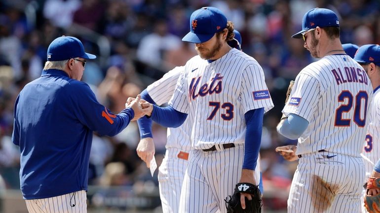 Jimmy Yacabonis of the Mets hands the ball to manager Buck Showalter...